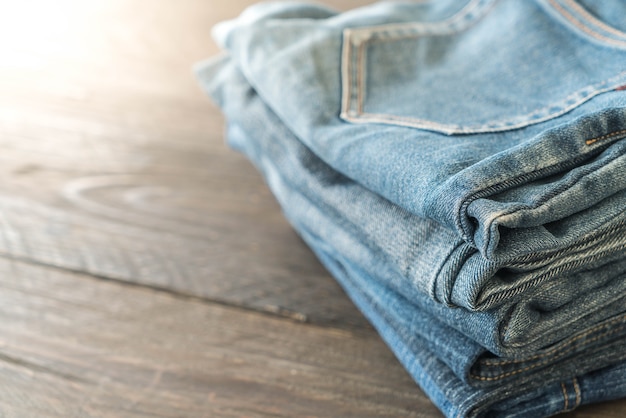 pile di jeans abbigliamento su legno