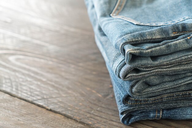 pile di jeans abbigliamento su legno