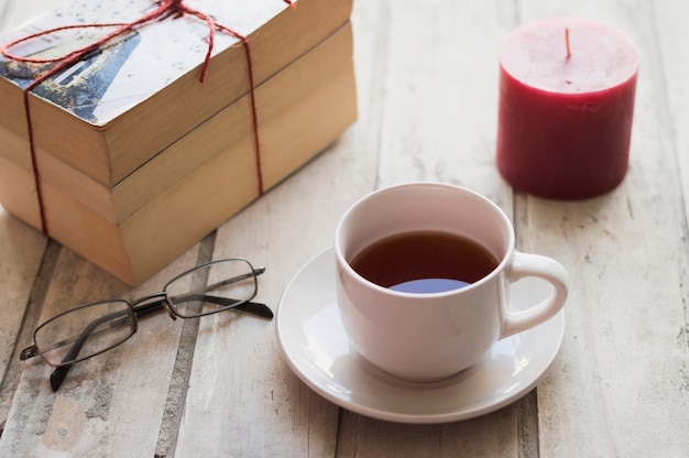 Pile di libri, caffè, candela e bicchieri