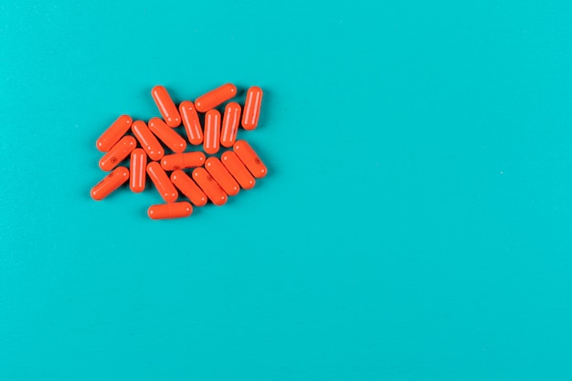 Pillole arancioni sulla superficie ciano