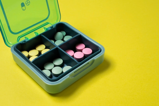 Pillole colorate ad alto angolo nella disposizione della scatola