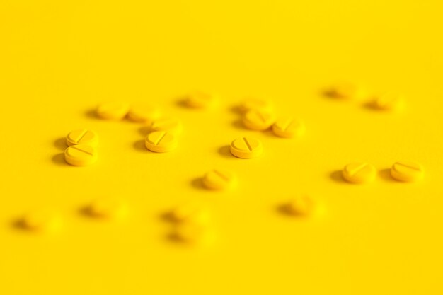 Pillole sparse su sfondo giallo