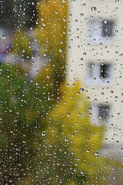 Pioggia. Il fondo stagionale di autunno con pioggia cade sulla finestra.