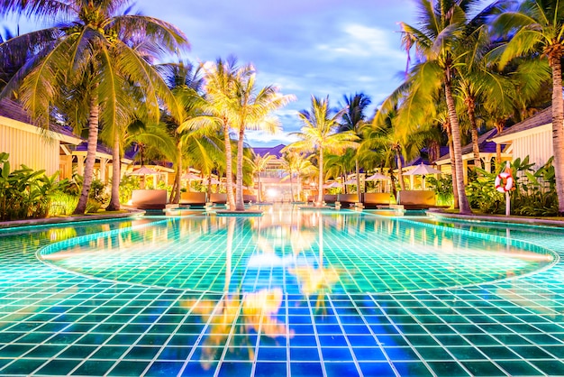 Piscina con palme in hotel resort di notte