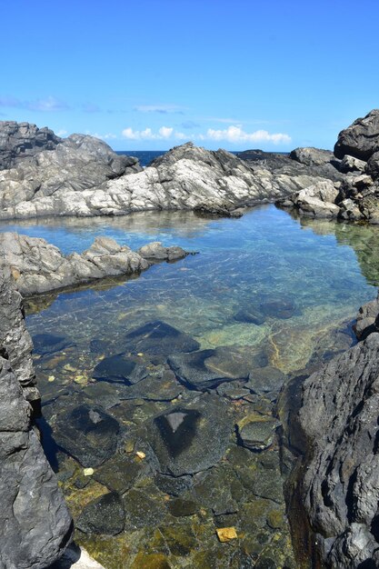 Piscina naturale tranquilla e panoramica tra le formazioni rocciose sulla costa di Aruba