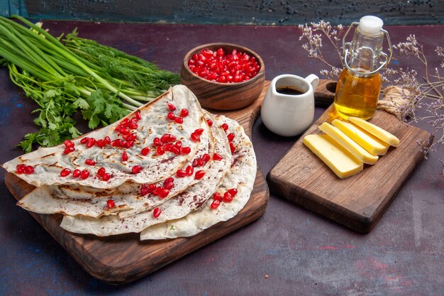 Pitas di qutabs di carne deliziosa vista frontale con melograni rossi freschi sulla carne di cibo pasto pita pasta superficie scura