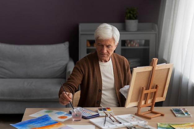 Pittore anziano che usa l'acquerello per la sua arte