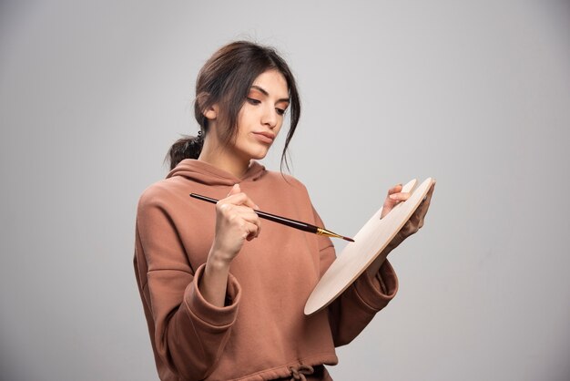 Pittore femminile che finge di prendere il colore dalla tavolozza