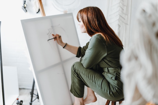 Pittura del disegno dell'artista della giovane donna in studio