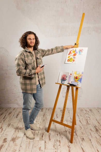 Pittura dell'artista maschio allo studio con gli acquerelli