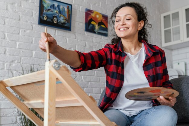 Pittura della donna del colpo medio al chiuso