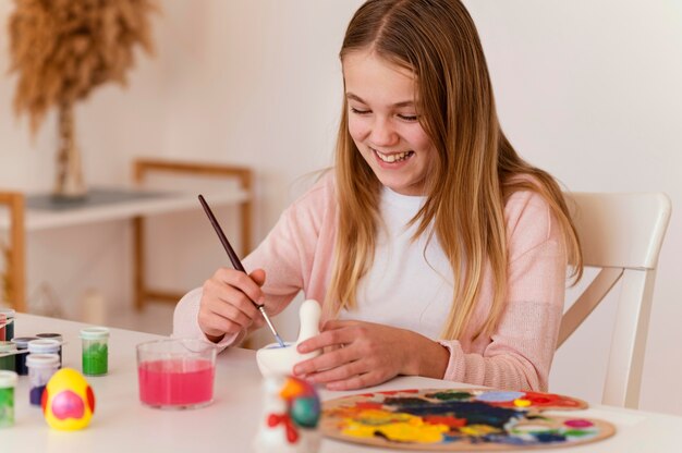 Pittura felice della ragazza del colpo medio