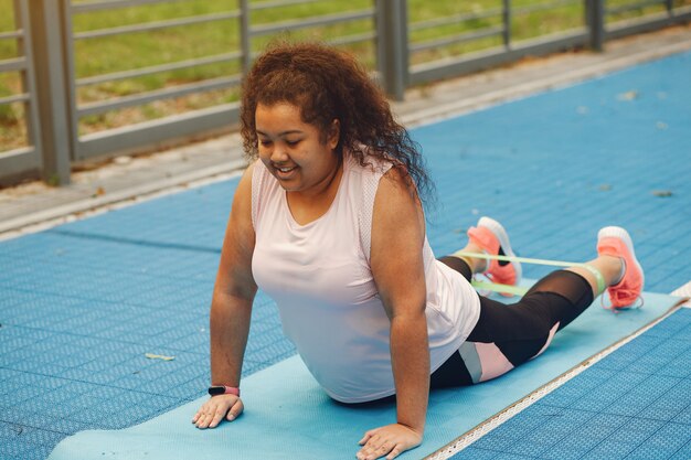 Più grande di una donna che fa esercizi di stretching