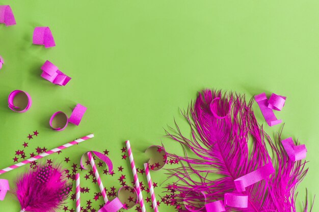 piuma viola con coriandoli su un tavolo verde