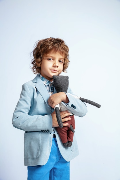 Piuttosto giovane ragazzo in abiti casual su bianco. In posa alla moda