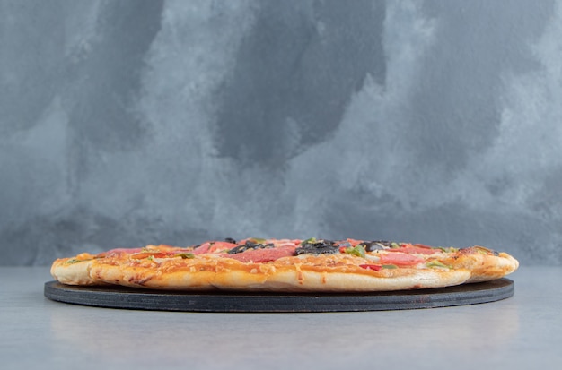 Pizza a fette su un bordo nero su marmo