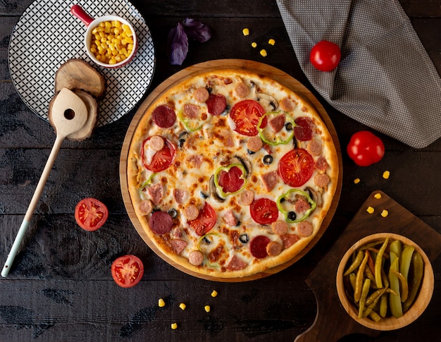 Pizza con fette di pomodoro e salame piccante.