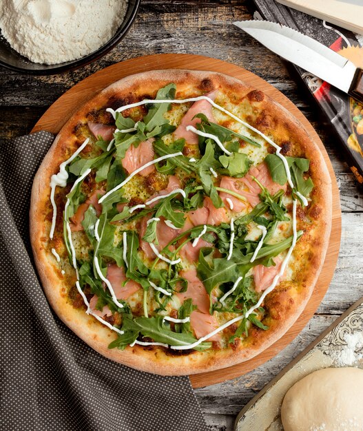 Pizza con salmone e rucola sul tavolo