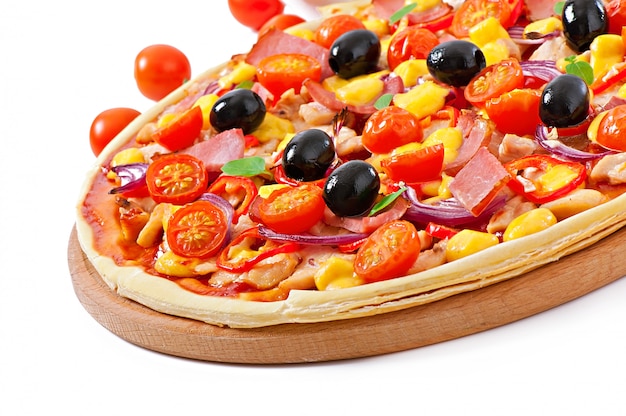 Pizza con verdure, pollo, prosciutto e olive isolati su bianco
