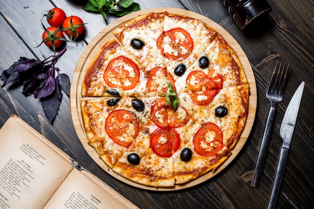 Pizza della margarita con la vista superiore del basilico verde oliva del pomodoro
