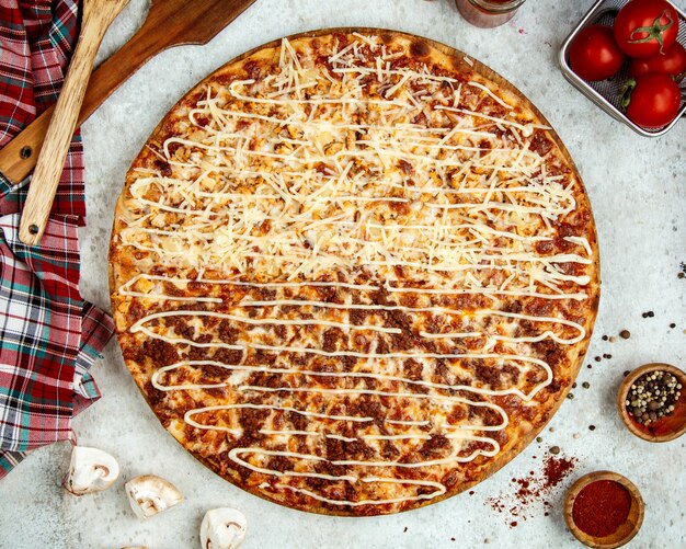 Pizza di carne con metà coperta di formaggio extra grattugiato