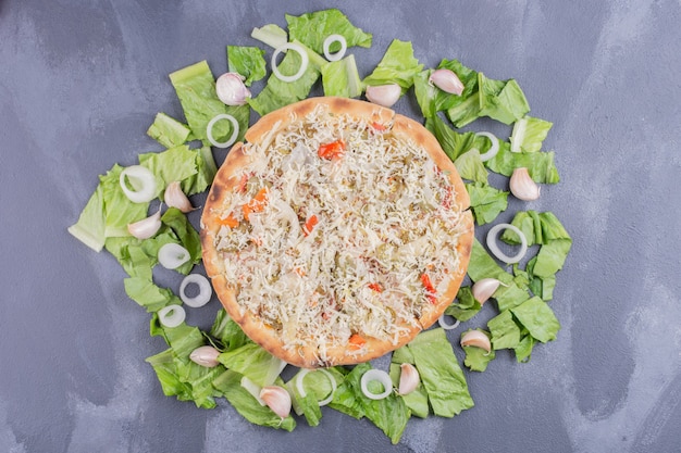 Pizza di formaggio di pollo sul blu con verdure fresche.