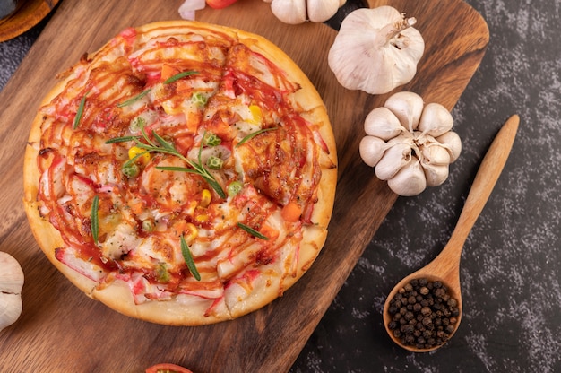 Pizza disposta su un piatto di legno.