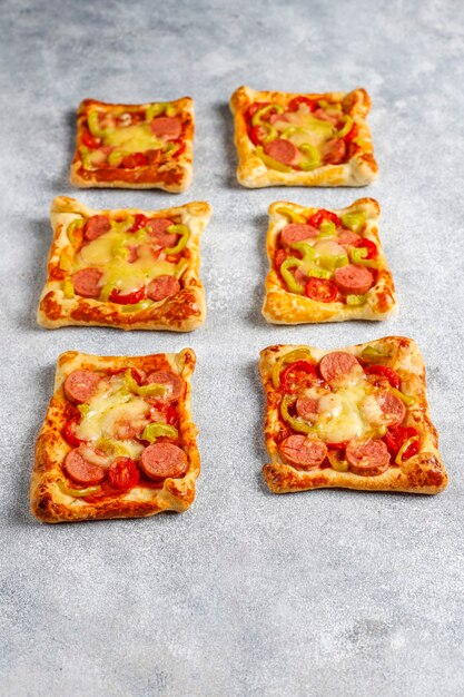 Pizzette di pasta sfoglia con salsiccia.