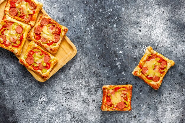 Pizzette di pasta sfoglia con salsiccia.