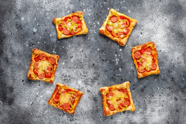 Pizzette di pasta sfoglia con salsiccia.