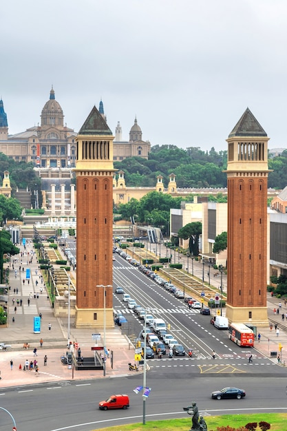 Plaza de Espana, le Torri Veneziane e il Palau Nacional di Barcellona, Spagna. Cielo nuvoloso, traffico