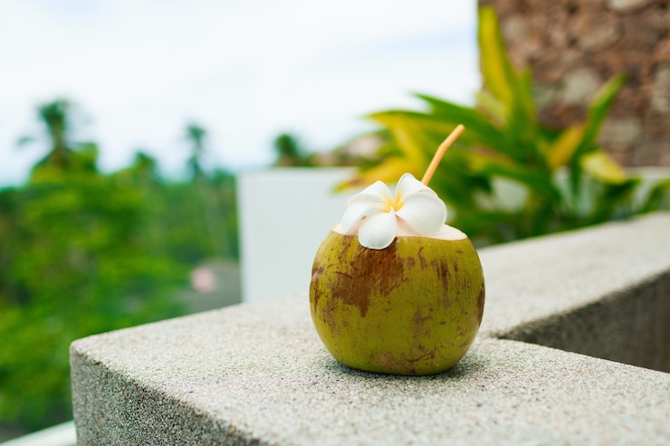 Foto gratuito plumeria decorata cocktail tropicale della noce di cocco sulla tavola.