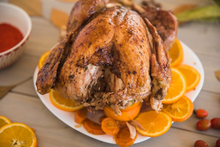 Foto gratuito pollo al forno con arance sul tavolo luminoso