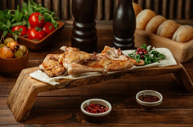 Pollo arrosto servito con erbe su un piatto di bambù