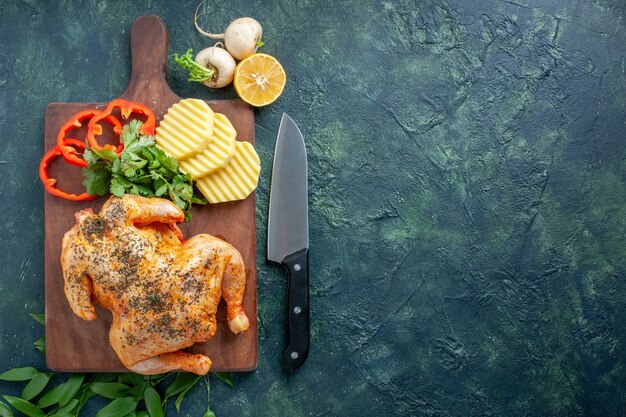 Pollo cotto vista dall'alto condito con patate sulla superficie scura