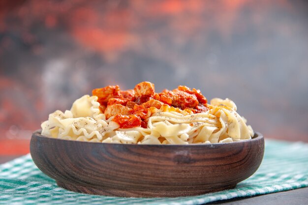 Pollo di vista frontale con il piatto di pasta della pasta sul piatto di pasta del pasto di colore di superficie scura