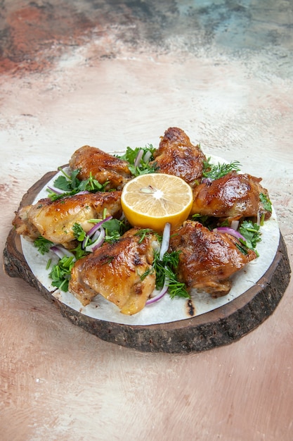 Pollo di vista laterale un pollo appetitoso su lavash con le erbe della cipolla del limone sulla tavola di legno