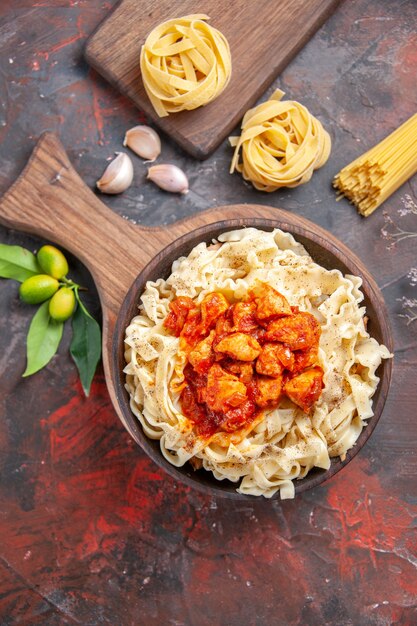 Pollo di vista superiore con il piatto di pasta della pasta sul piatto della pasta della pasta del pavimento scuro scuro