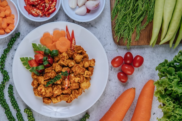 Pollo fritto alle erbe con peperoncino, pomodoro, cetriolo, carota e pepe fresco.