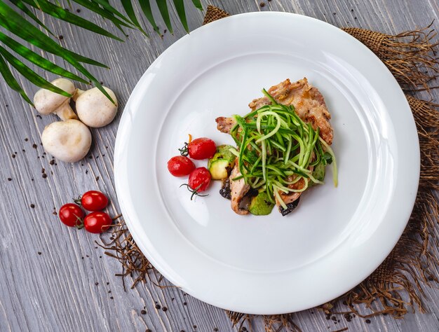 Pollo fritto vista dall'alto con cetriolo e pomodorini