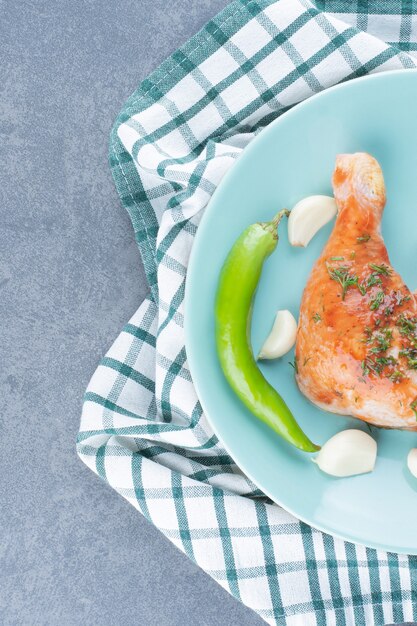 Pollo marinato con aglio e pepe sulla zolla blu.