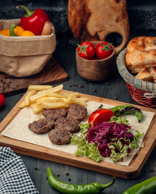 polpette di carne servite con patatine fritte e insalata verde