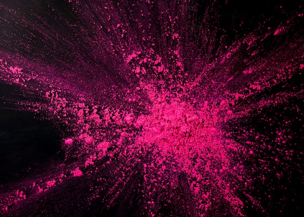 Polvere di colore rosa che spruzza sul fondale nero