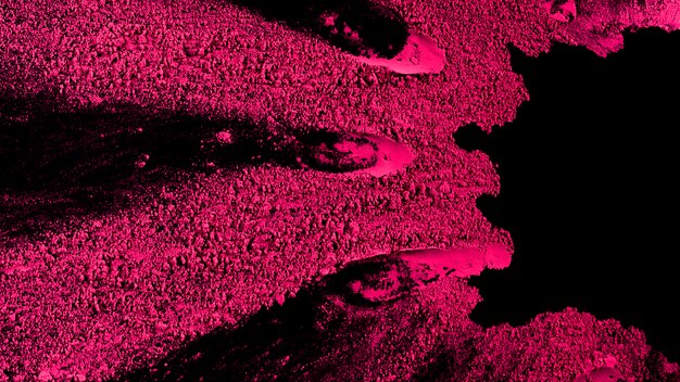 Polvere di holi rosa su superficie nera