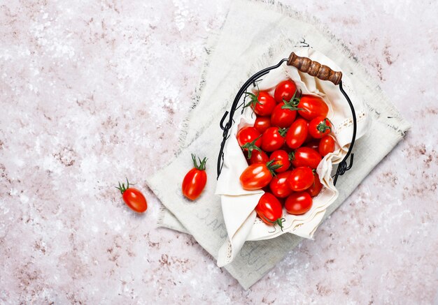 Pomodori ciliegia di vari colori, pomodori ciliegia gialli e rossi su sfondo chiaro