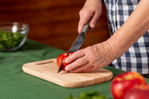 Pomodori di taglio della donna del primo piano