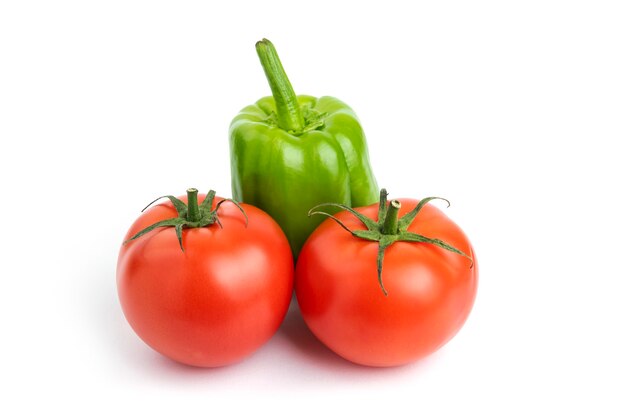 Pomodori e pepe organici freschi sopra fondo bianco.