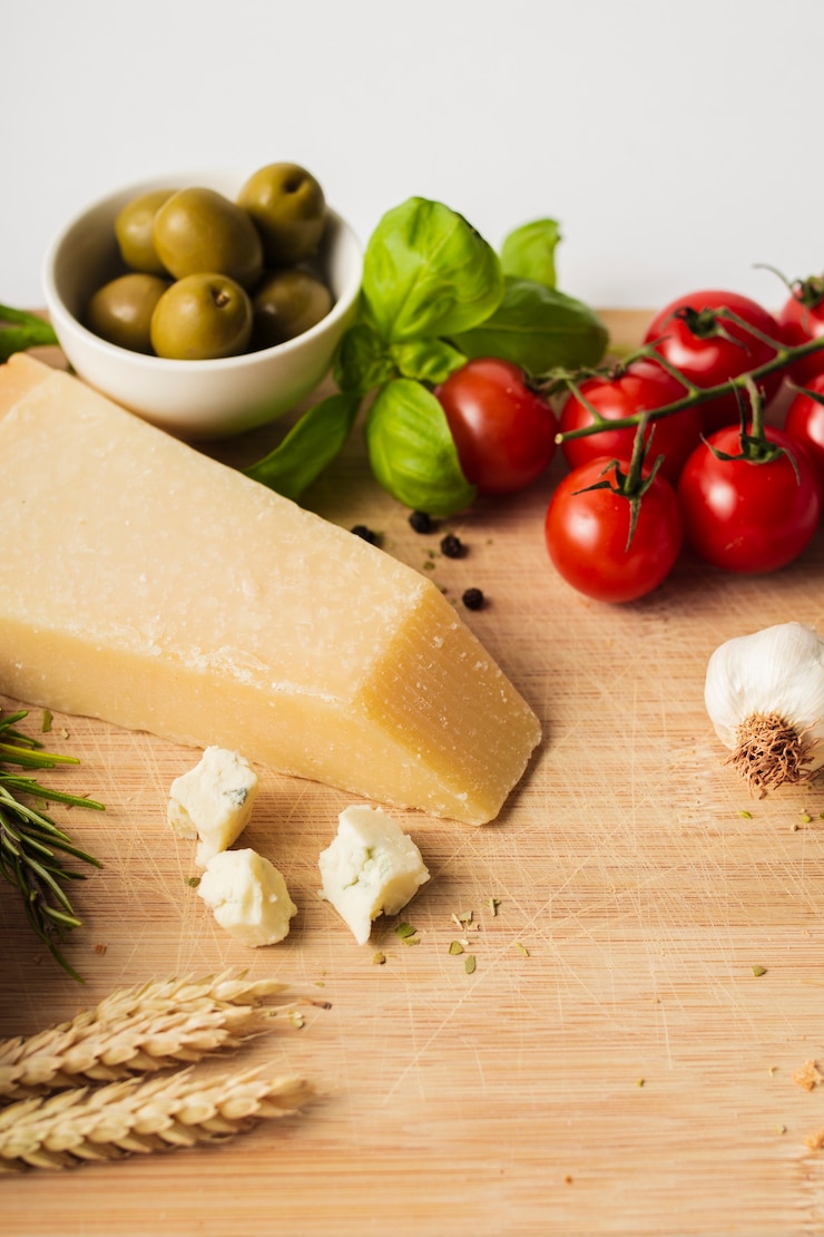 Foto gratuito pomodori ed aglio del parmigiano dell'angolo alto sul tagliere