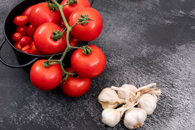 Pomodori freschi in una pentola e aglio