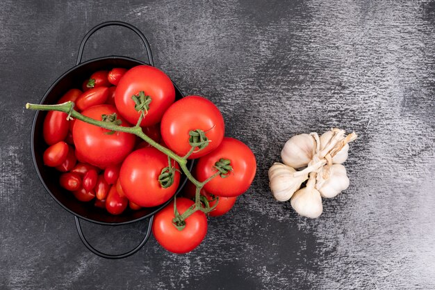 Pomodori freschi in una pentola e aglio